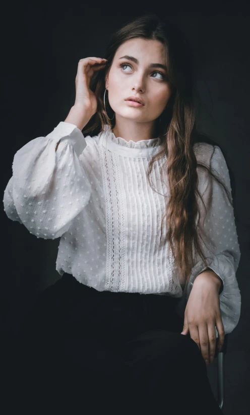 a woman with long hair sitting on a chair