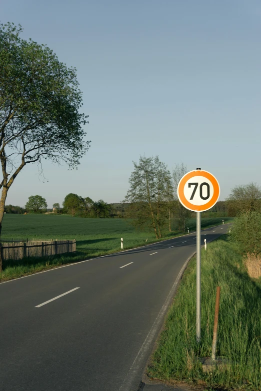 an orange sign that is next to a street