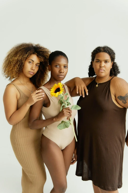 three beautiful women pose for a picture in bathing suits