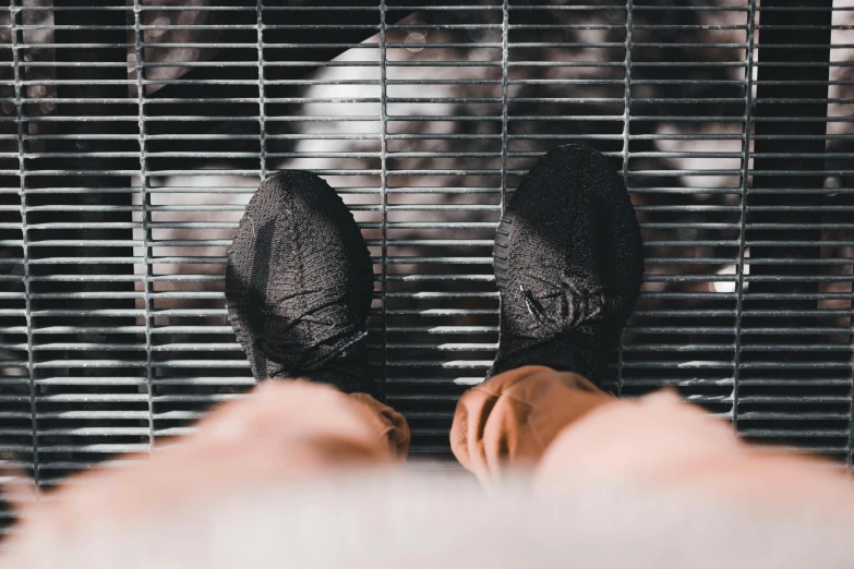 the view through blinds shows a person's feet and feet