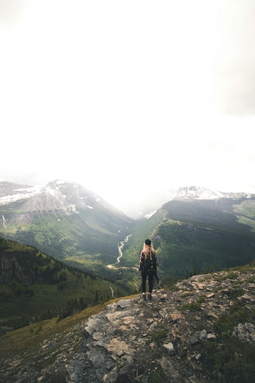 man standing on top of large rock on a mountain