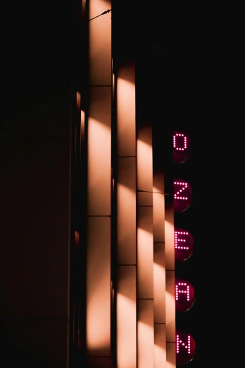 three building walls lit up with pink letters