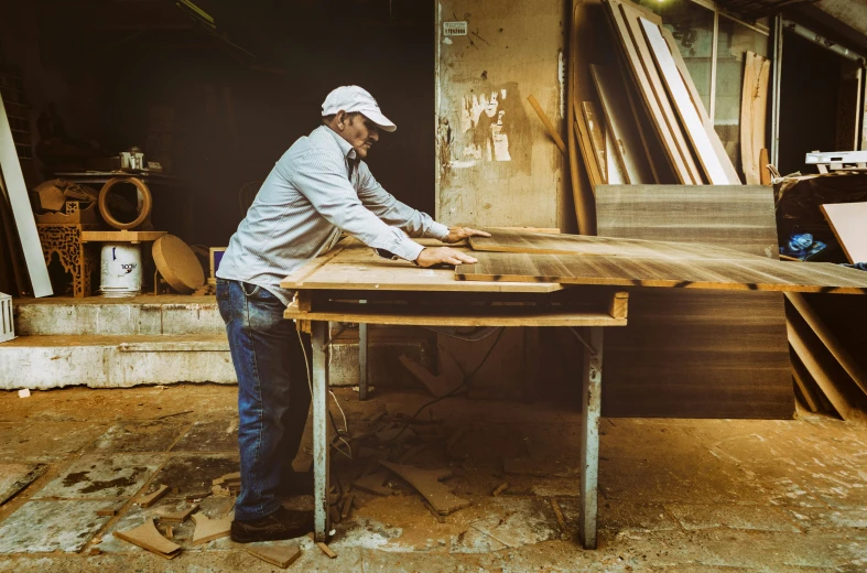 an older man is sanding up wood and installing the table