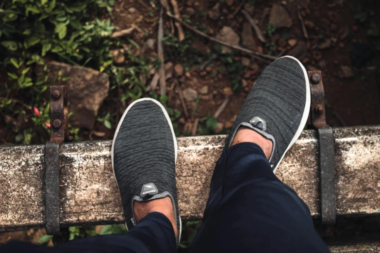 the feet of a person in slippers standing on a bench