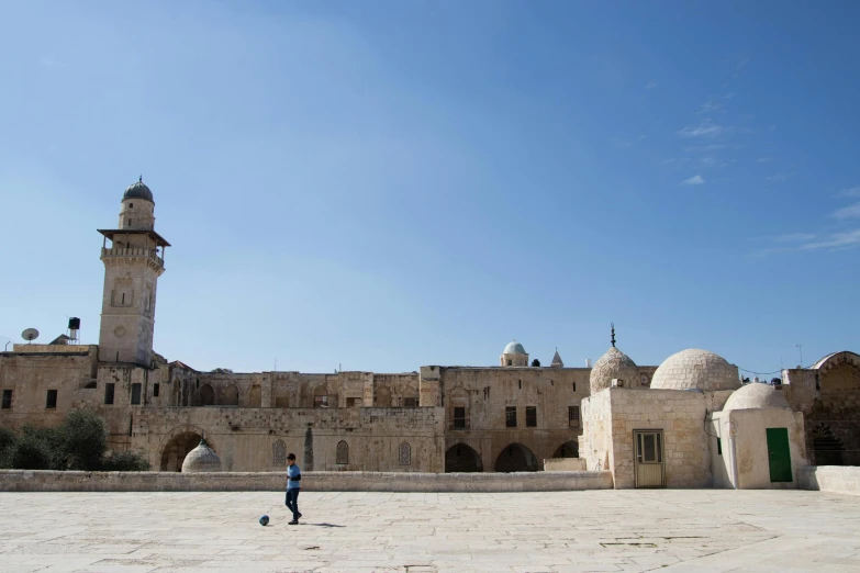 a man playing frisbee in front of an old building