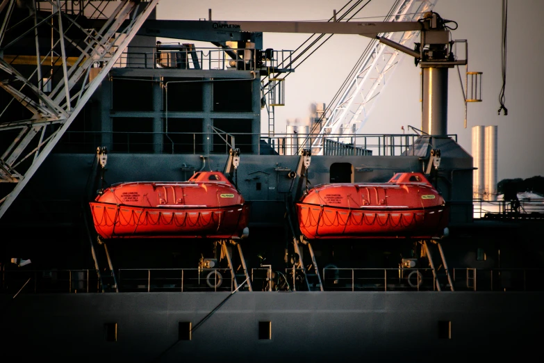 two ships are parked at the dock and one is painted red