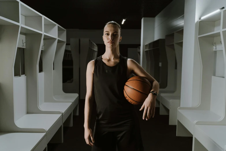 a female basketball player in black and white poses for a po