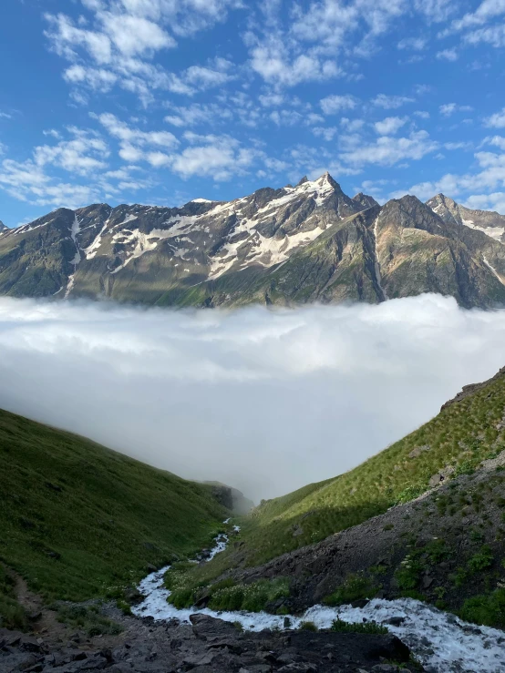 a green mountain hillside covered with low clouds