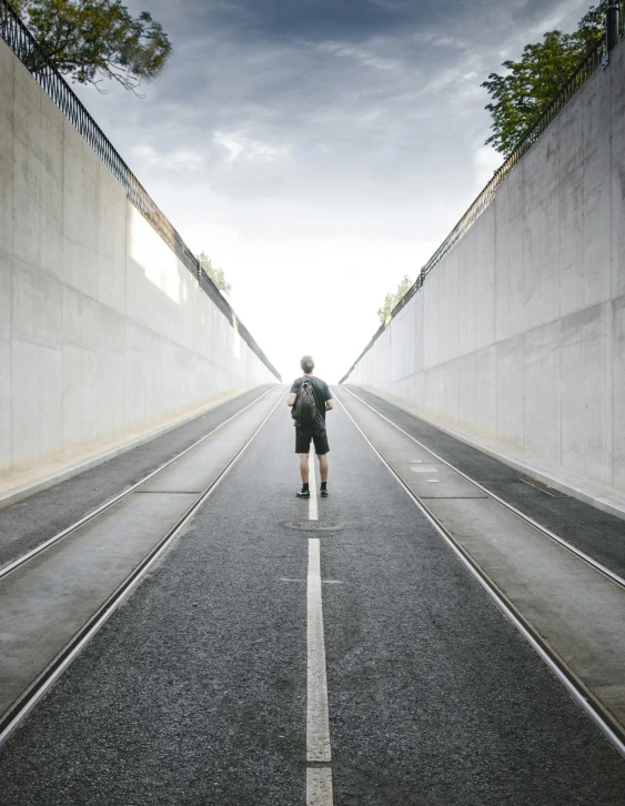 the person walks on one of two parallel railroad tracks