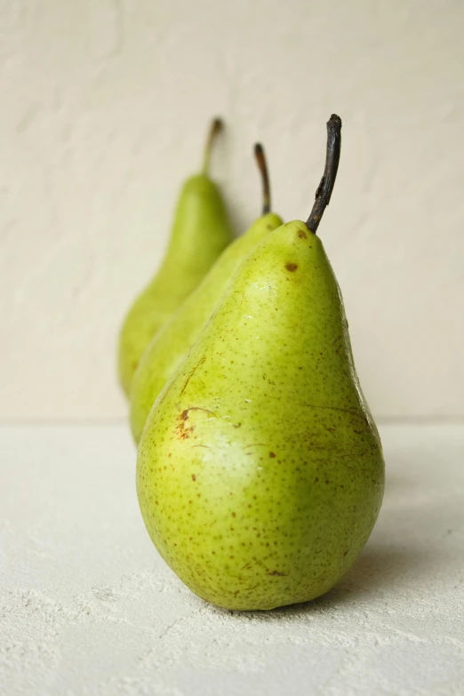 two green pears are lined up in the form of a pear