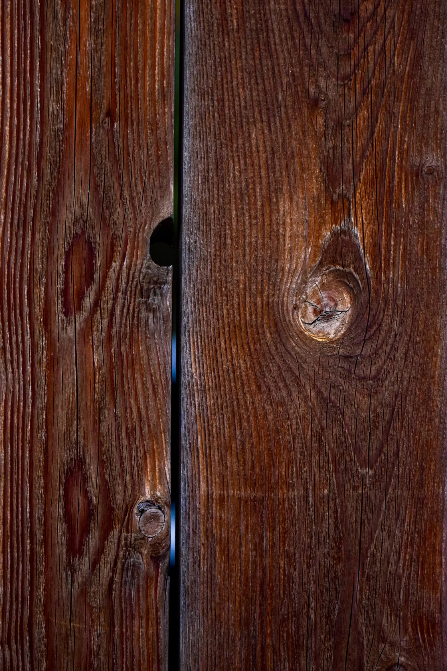 two brown wooden door handles on a dark wood wall