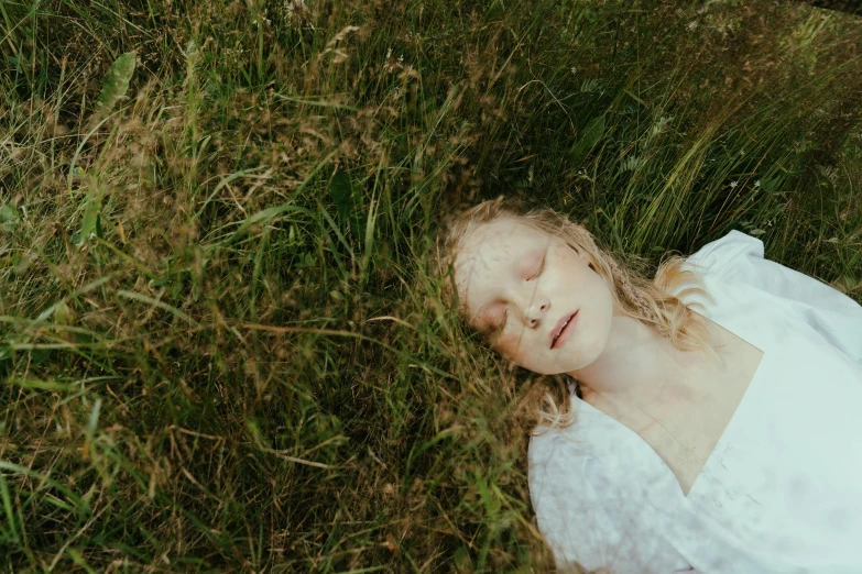 a child lays in the grass looking at camera
