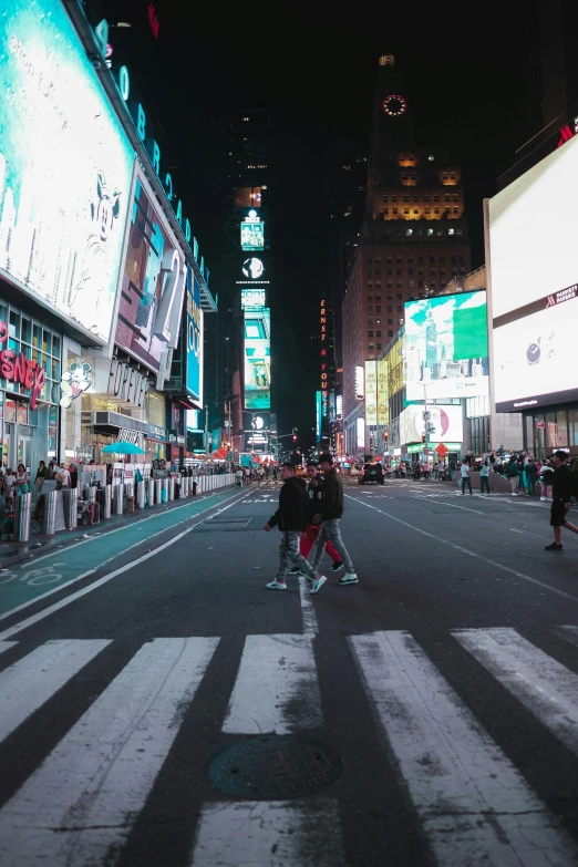 many people are walking through an empty city at night