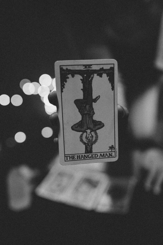 a person holds up an inverted tarot deck with a blurred background