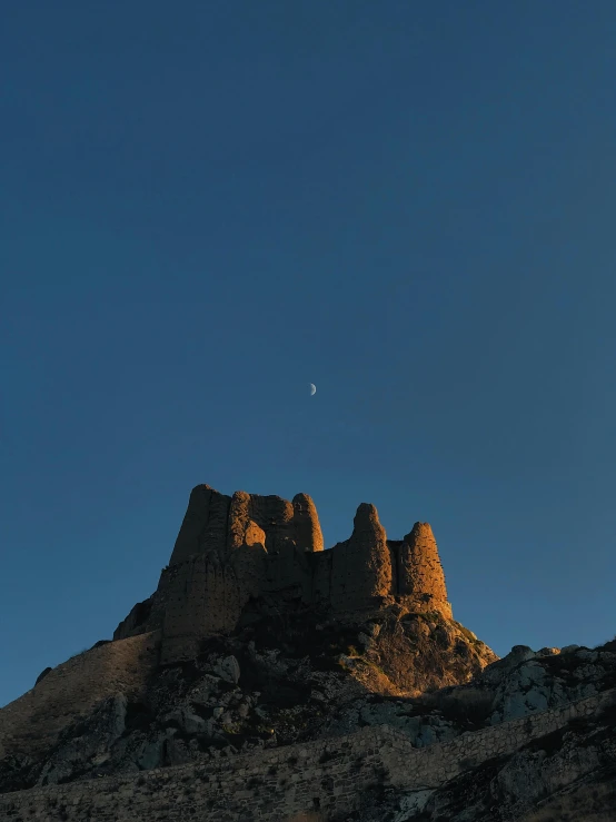 a moon is seen in the distance near a mountain