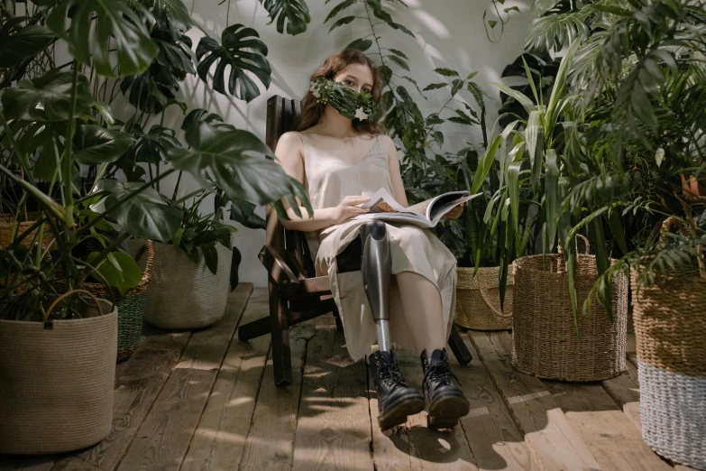 a woman sits on a wooden platform surrounded by lots of plants