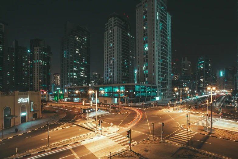 a city at night has skyscrs and cars lights in the foreground