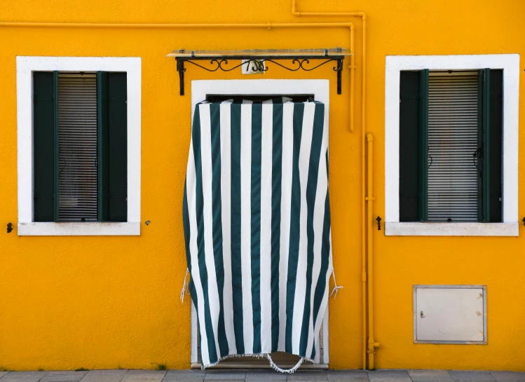 a green and white  curtain on the side of a building