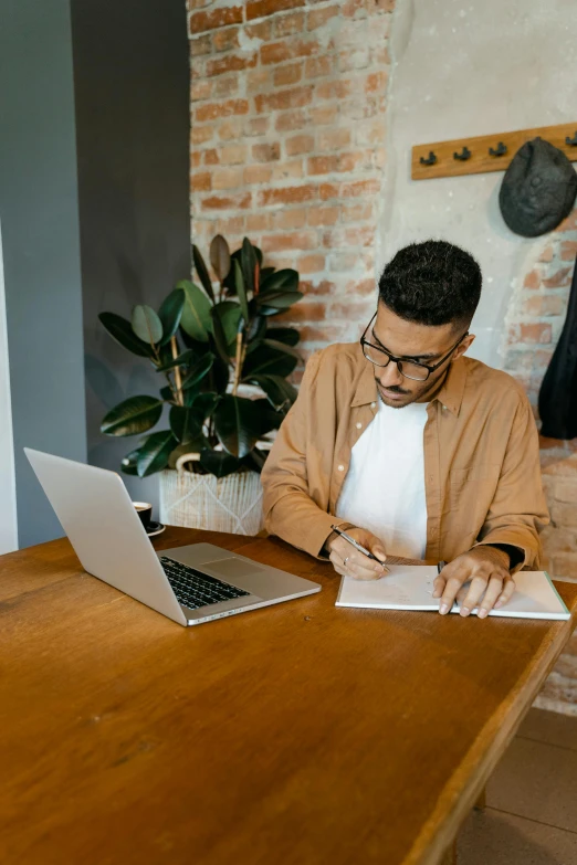 a man sitting at a table with a laptop computer