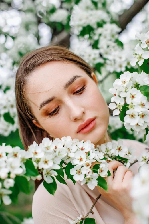 a woman is picking on some white flowers