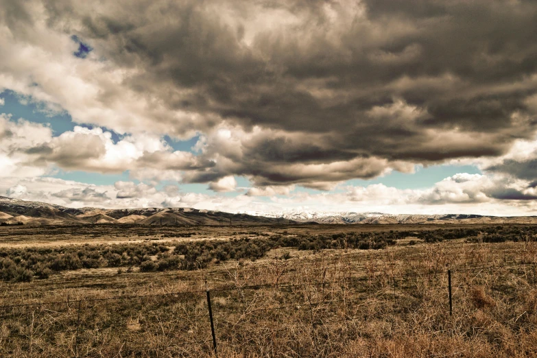 a large open field surrounded by mountains in the distance