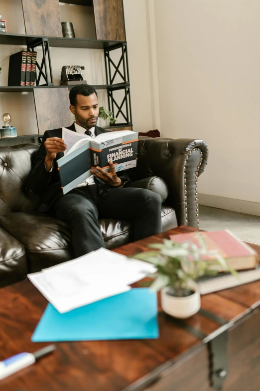 man sitting on the couch holding his book