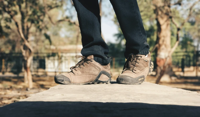 a person standing on a rock with trees in the background