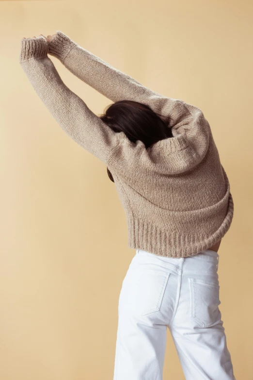 a woman standing and looking to her left with the back turned over her head