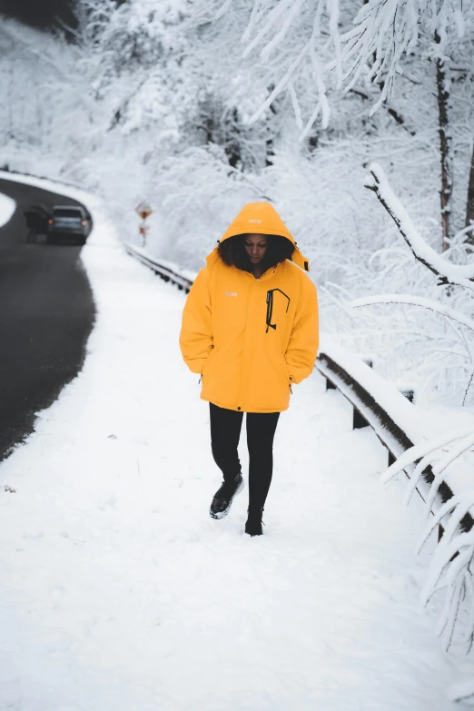 the woman is walking down the snowy road