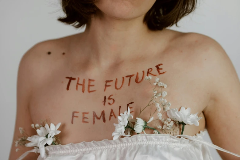 the woman has tattoos that say the future is female