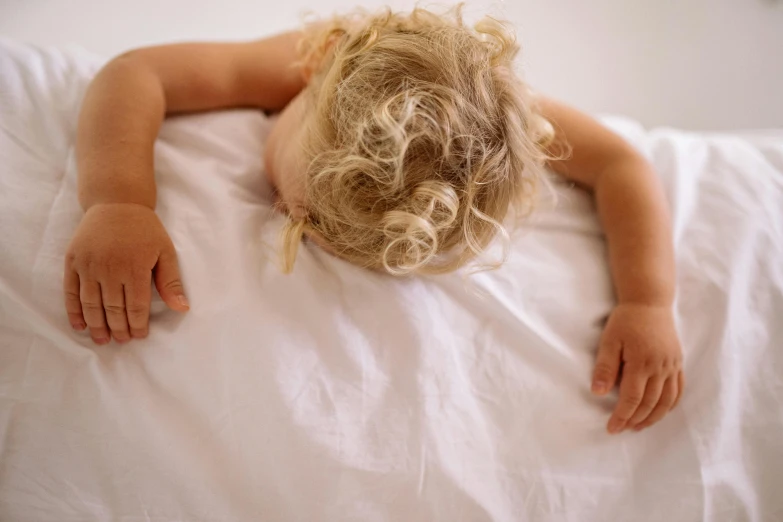 a child sleeping in bed on a pillow