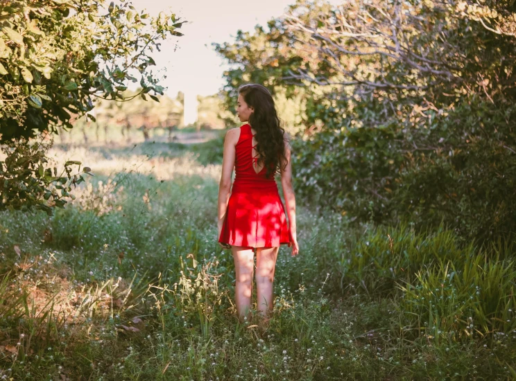 a beautiful young woman standing in the grass