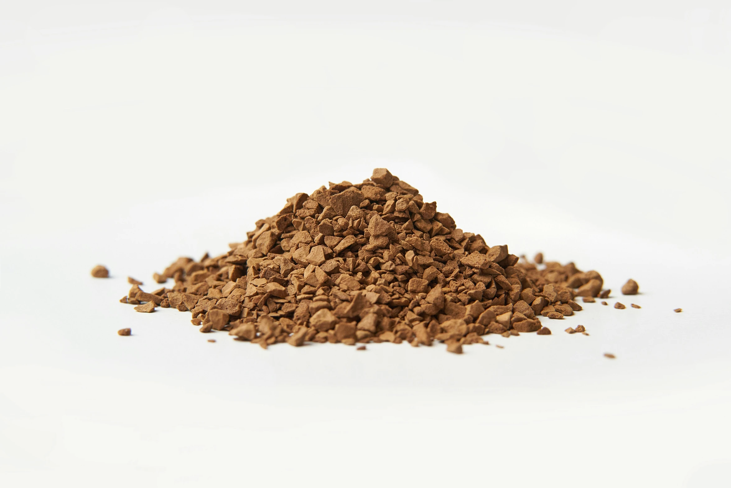a pile of ground cocoa powder on a white background