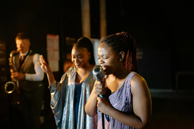 a woman holding a microphone with a band in the background