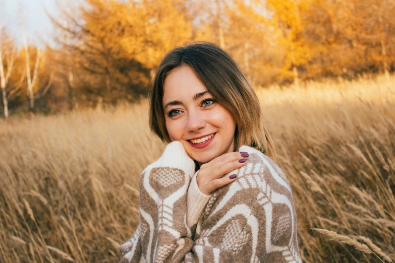 a woman wearing a white sweater is posing for a picture