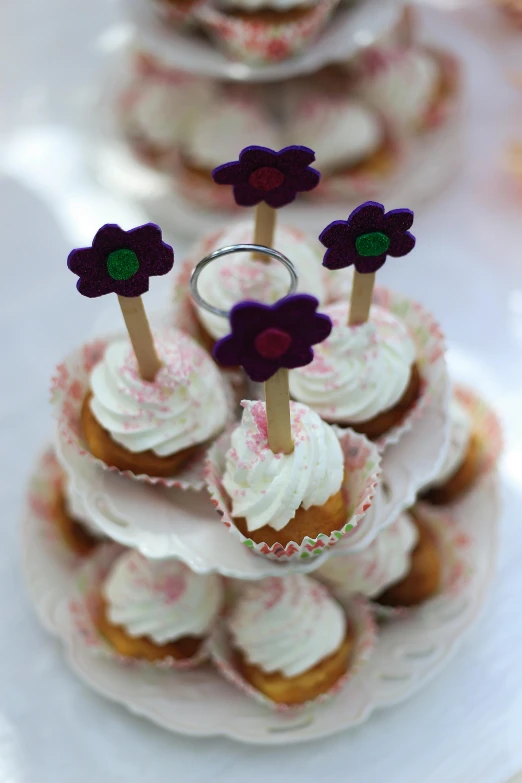 there are cupcakes on the small cake plate