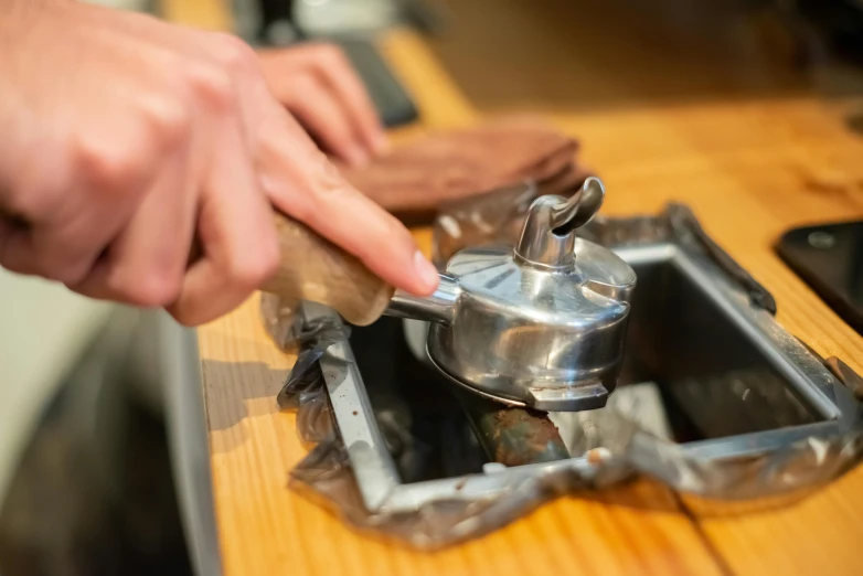 someone cleaning a wooden  board with a hand in a kitchen sink