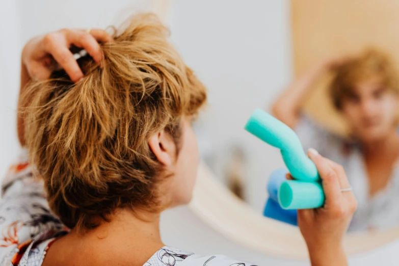 a woman is blow drying her hair