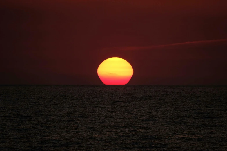 the sun is setting over the water at the beach