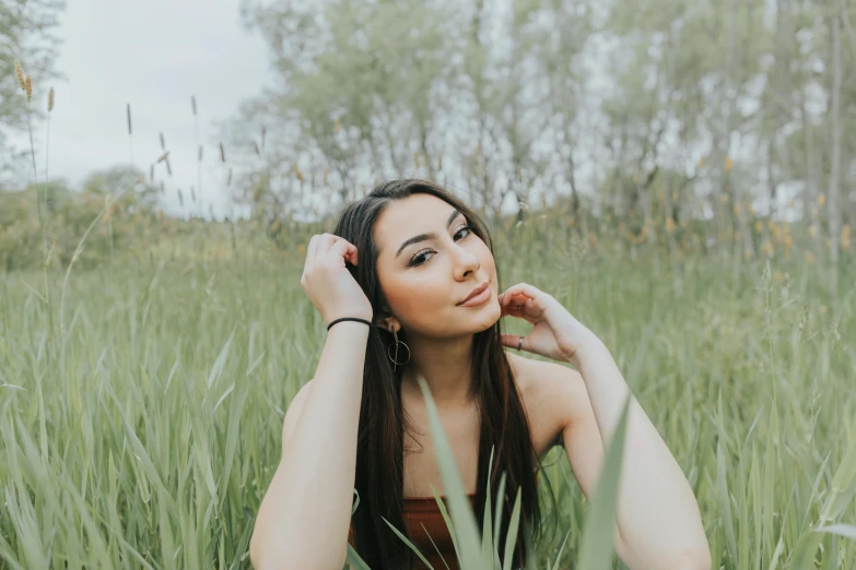 a girl with long brown hair is in some tall grass