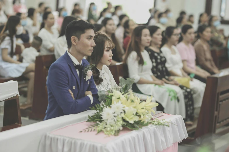 a couple in blue suit sitting in front of people