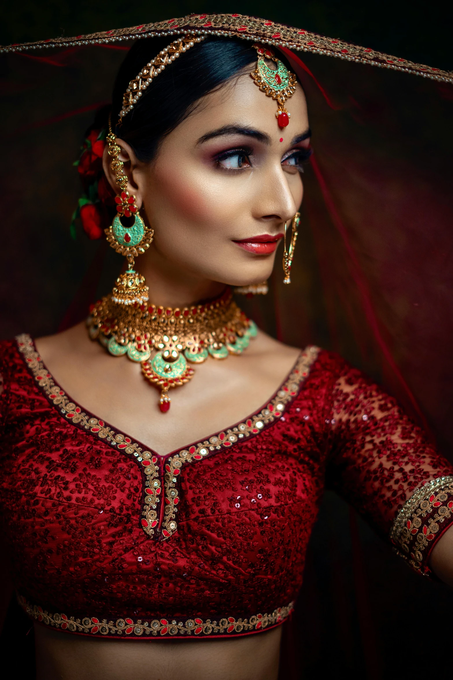 a woman in red dress with necklace and earrings