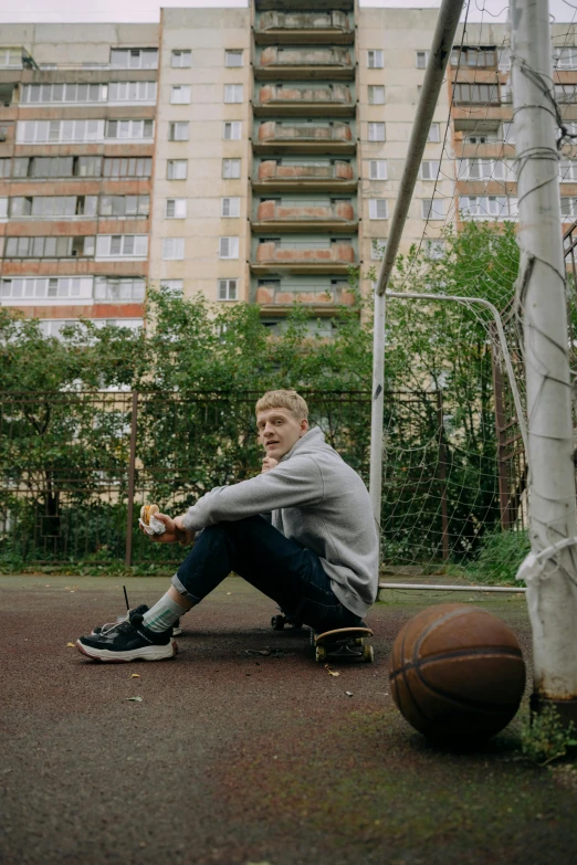 a man sitting down on the ground with his legs crossed