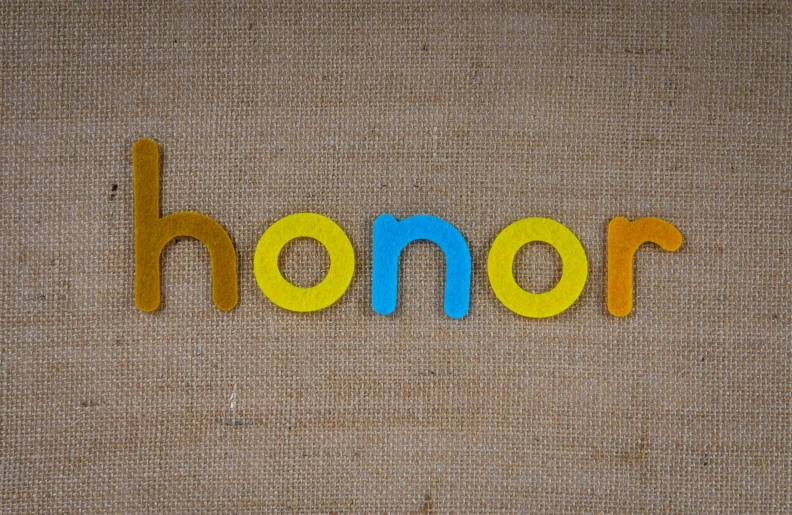 the word honor spelled with cut out letters on the wall