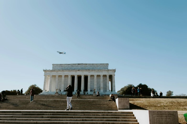 people walking along stairs and steps in front of a monument