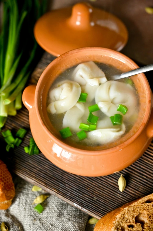 a bowl of dumpling soup sitting on top of a table