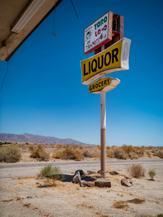 a small gas station sign in the middle of nowhere
