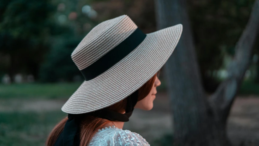 woman in white dress and hat sitting down