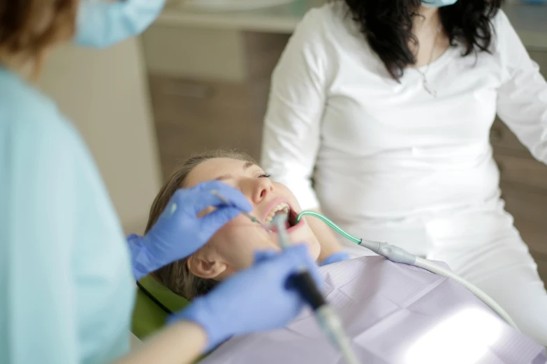 a woman in a white shirt and gloves in a dental clinic