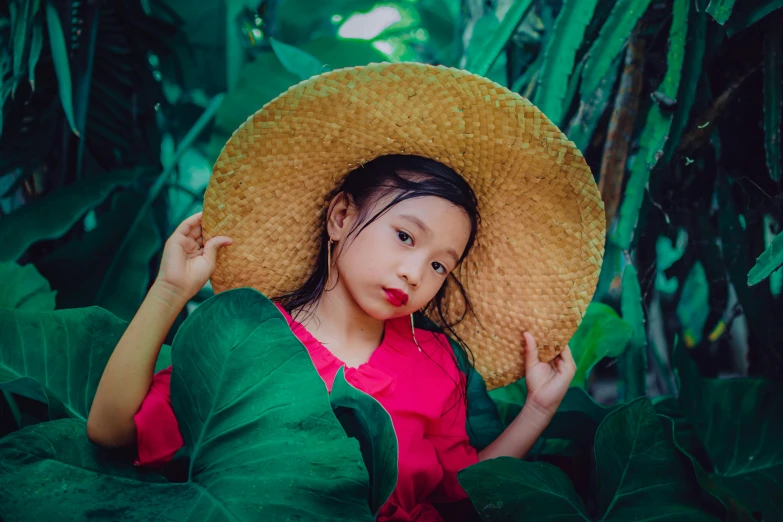 a girl wearing a yellow hat in the jungle